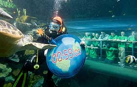 Pictured with naturalist and broadcaster Nick Baker as a diver carries a symbolic �time-bomb� earth through the ocean tank at the National Sea Life Centre, are from left to right: Standing - Tierney Carter, Rebecca Johnson, Amber Rowland (Nick Baker), Ricky Froud, Matthew Newsome and Abigale Rudland. Kneeling - Molly Clayton, Hannah Layton and Kwabe Tenkorang.  Click on this photo to see a larger version >>>